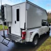 White lightweight overland F350 slide-in on neighborhood street