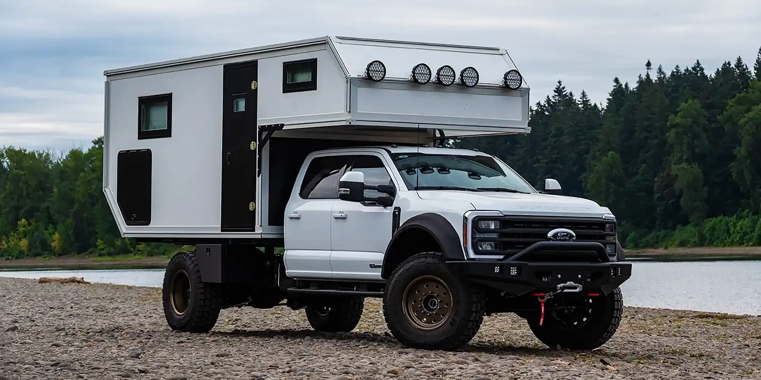 Globe Trekker cabover camper at river.